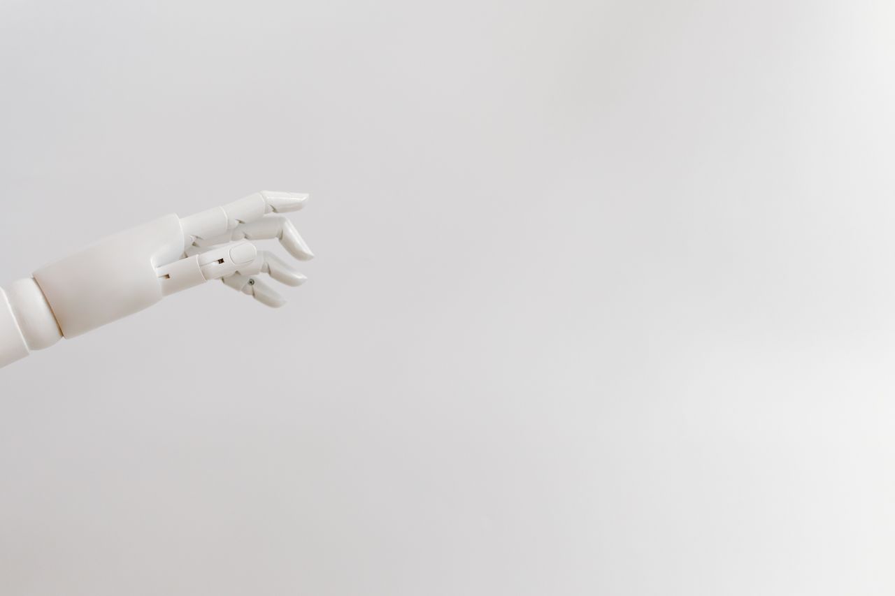 The Art of Drawing Readers In: Your attractive post title goes here Minimalist image of a robotic hand reaching out on a white background.